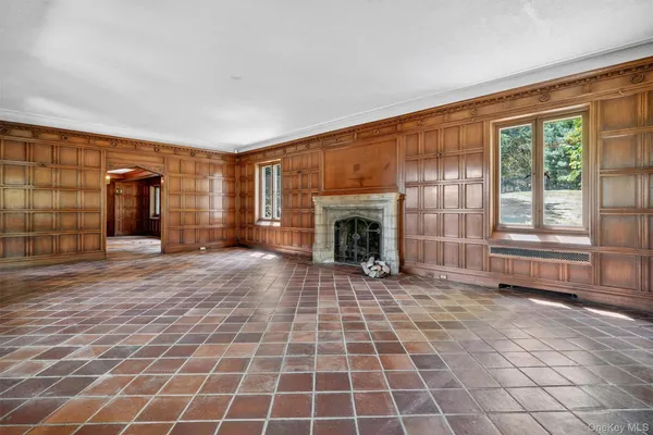 a large white kitchen with a stove a sink dishwasher and a fireplace with wooden floor