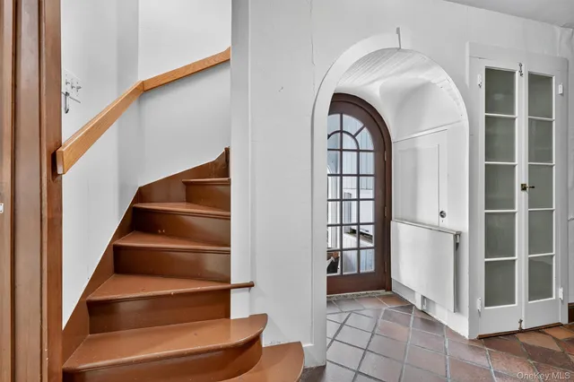 a large white kitchen with kitchen island a large counter top a sink stainless steel appliances and cabinets
