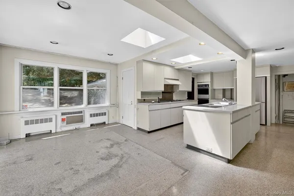 a view of an empty room with a fireplace and a window