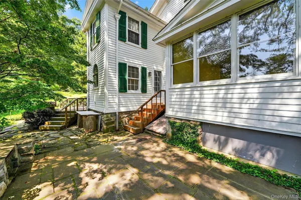 a front view of a house with a garden and trees