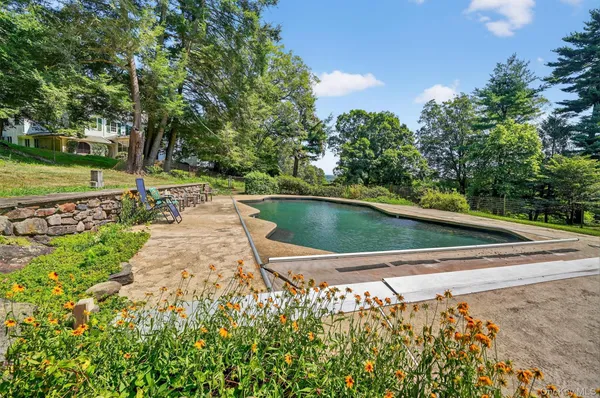 a front view of house with yard and trees in the background