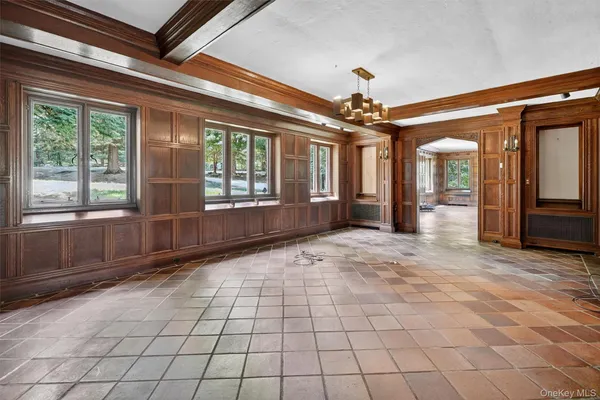 a view of a hallway with wooden floor and a living room