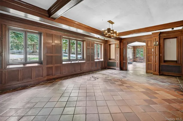 a view of a hallway with wooden floor and a living room