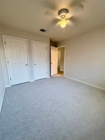 a view of a room with a ceiling fan window and a ceiling fan