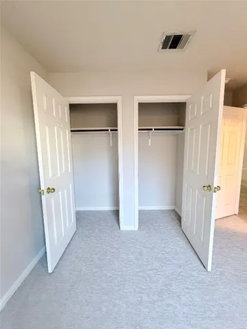 an empty room with closet and windows