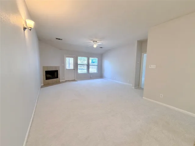 a view of a livingroom with a fireplace and windows