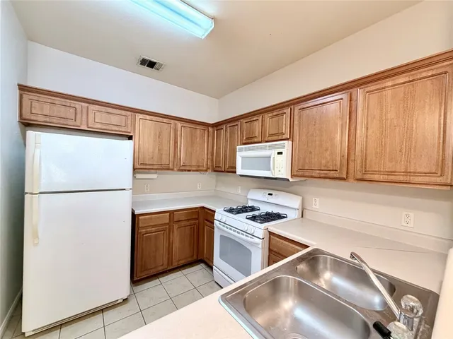 a kitchen with stainless steel appliances granite countertop a refrigerator sink and stove