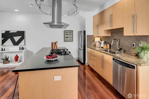 a kitchen with stainless steel appliances kitchen island a stove a table and chairs in it