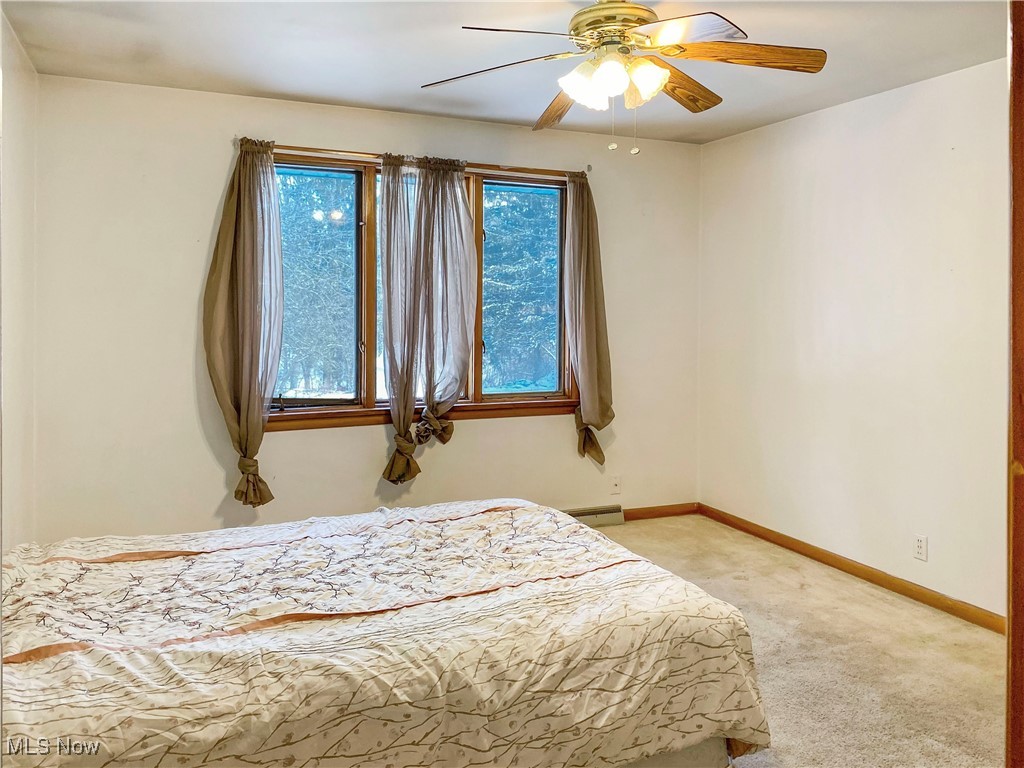 1034 Straub Road West Mansfield, OH 44904 - Photo 15 of 27 Bedroom with ceiling fan, a baseboard heating unit, and light carpet