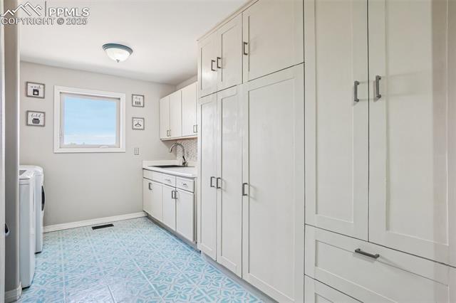 14425 Granby Road Colorado Springs, CO 80921 - Photo 19 of 45 Laundry room featuring washer and dryer, baseboards, cabinet space, and light floors