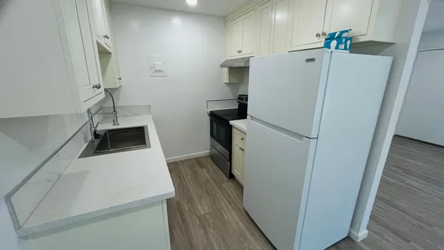 a white refrigerator freezer and a stove sitting inside of a kitchen