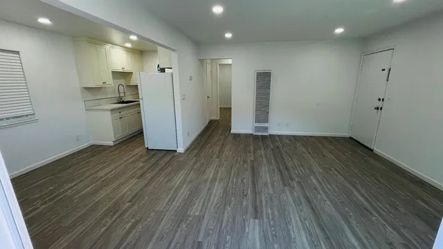 a view of a kitchen with wooden floor and a sink