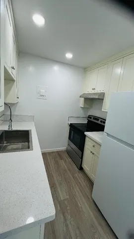 a kitchen with granite countertop a sink a stove and cabinets