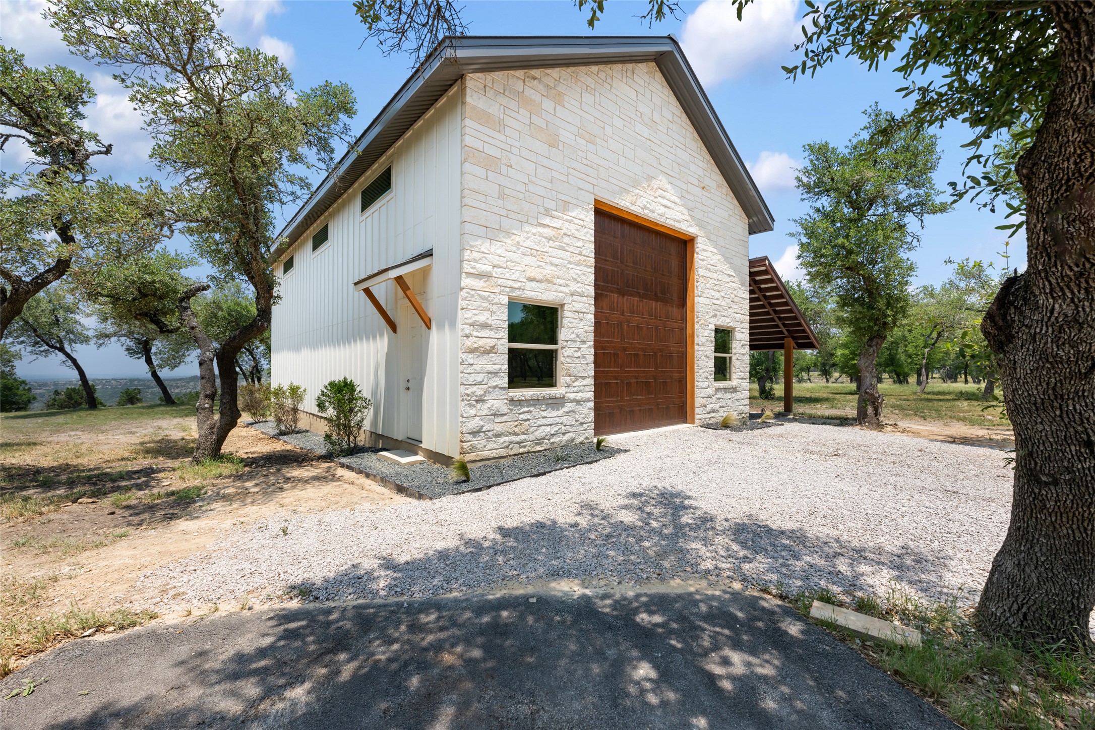 1276 Canyon Crossing View Dripping Springs, TX 78620 - Photo 25 of 33 a front view of a house with a yard and garage
