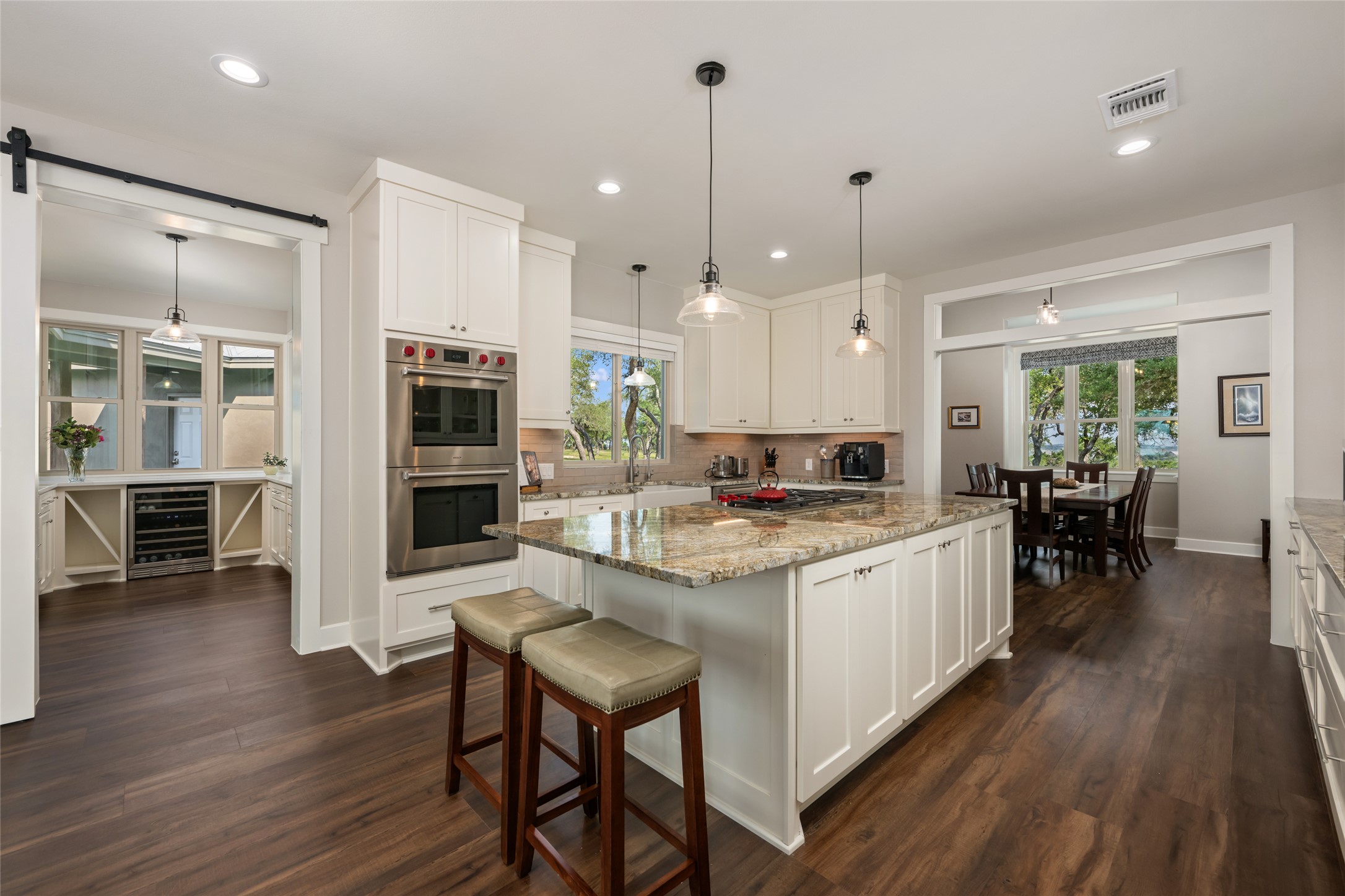 1276 Canyon Crossing View Dripping Springs, TX 78620 - Photo 7 of 33 a kitchen with stainless steel appliances granite countertop a stove refrigerator and chairs with wooden floor