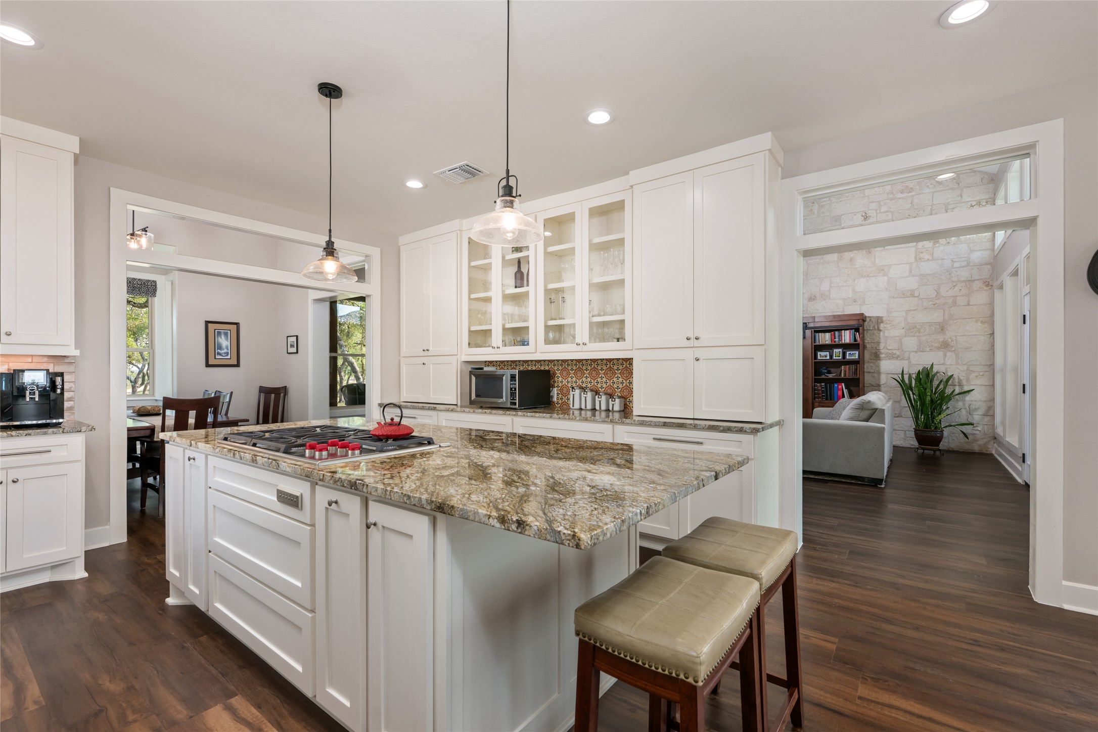 1276 Canyon Crossing View Dripping Springs, TX 78620 - Photo 8 of 33 a kitchen with a stove a sink a dining table and chairs