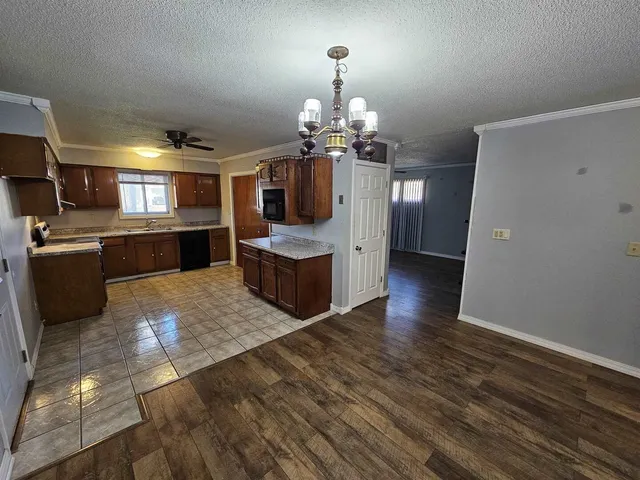 a large kitchen with granite countertop a large counter top space appliances and cabinets