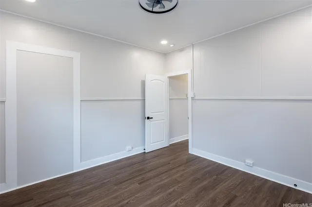a view of an empty room with wooden floor and closet