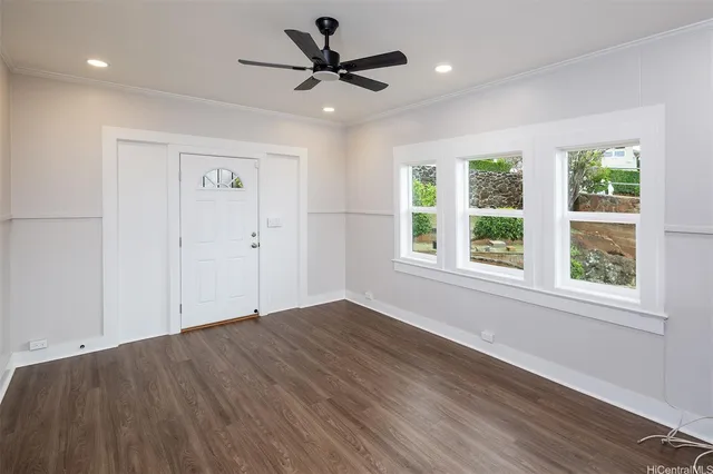 a view of empty room with wooden floor and fan
