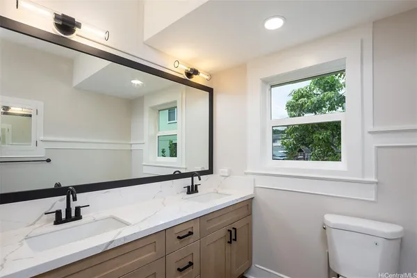 a bathroom with a double vanity sink toilet and a mirror