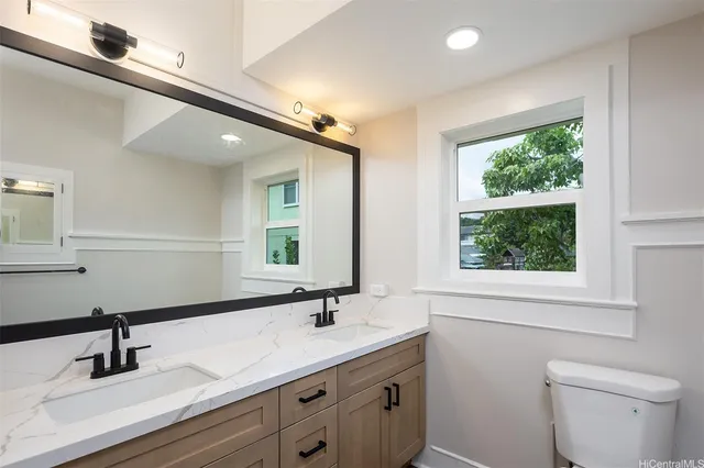 a bathroom with a double vanity sink toilet and a mirror