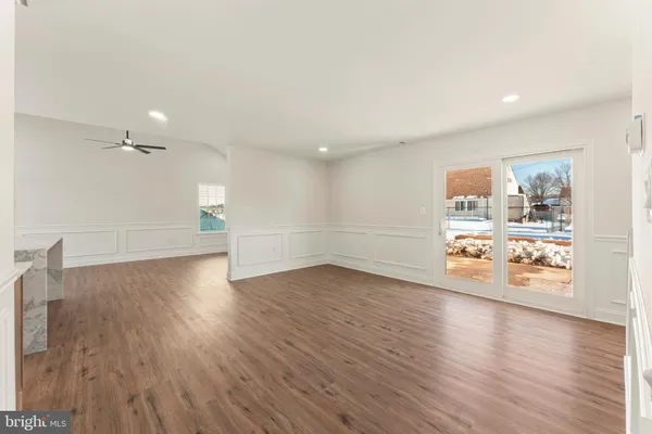 a view of a big room with wooden floor and windows