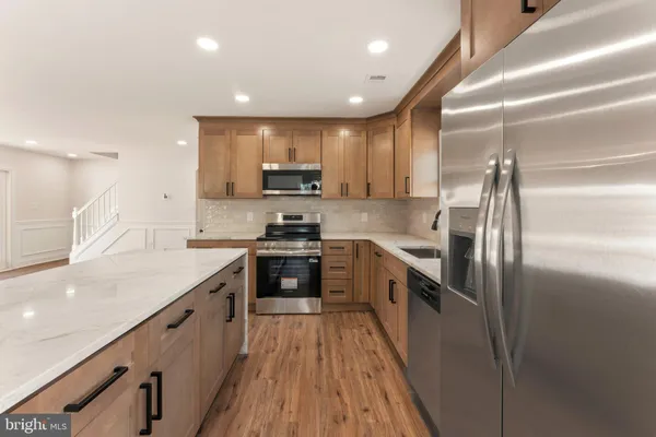 a kitchen with kitchen island granite countertop stainless steel appliances cabinets a sink and a counter top space