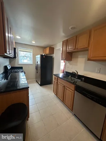 a kitchen with a refrigerator and a stove top oven