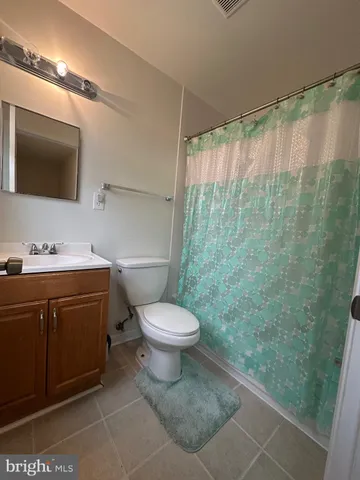a bathroom with a sink a toilet a mirror and shower