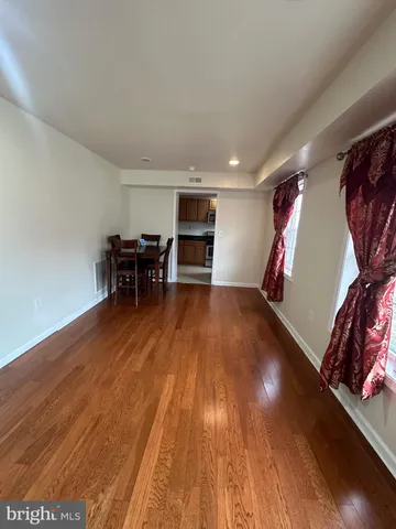a view of a room with wooden floor furniture and windows
