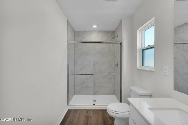 a bathroom with a toilet a sink and a large mirror