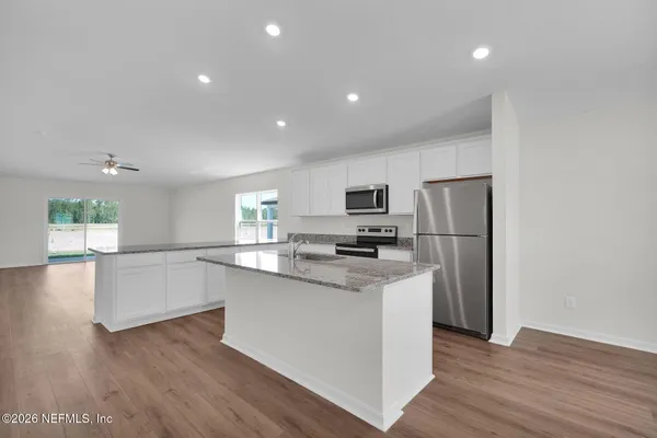 a kitchen with stainless steel appliances a refrigerator and a stove top oven