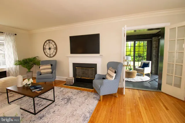 a living room with furniture a fireplace and a floor to ceiling window