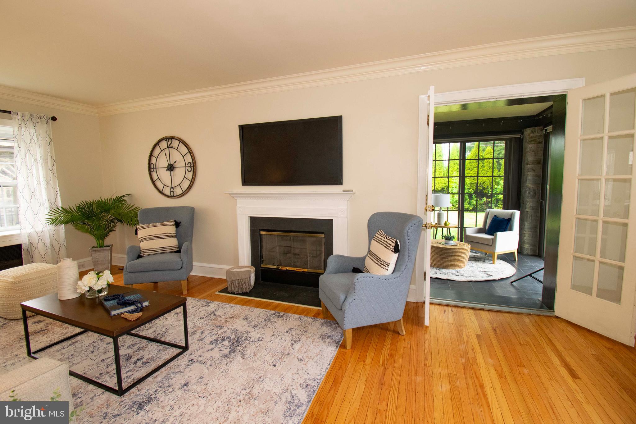501 East Manoa Road Havertown, PA 19083 - Photo 7 of 42 a living room with furniture a fireplace and a floor to ceiling window