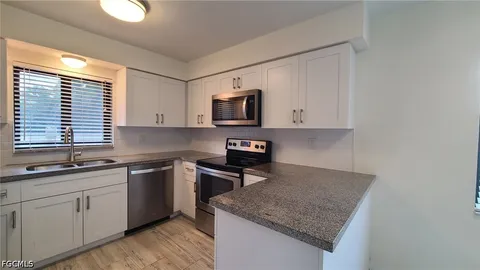 a kitchen with stainless steel appliances granite countertop a sink stove and microwave