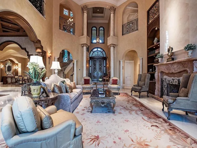 a living room with furniture a fireplace and potted plants