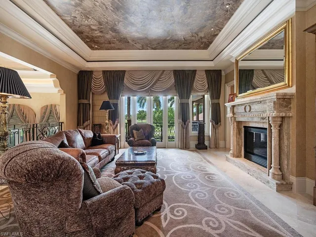 a living room with furniture a fireplace and a floor to ceiling window