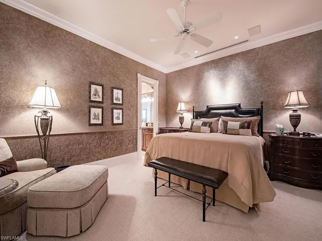 a spacious bedroom with a bed and a lamp