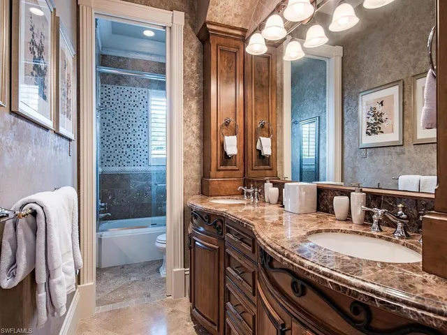 a bathroom with a granite countertop sink a toilet and bathtub