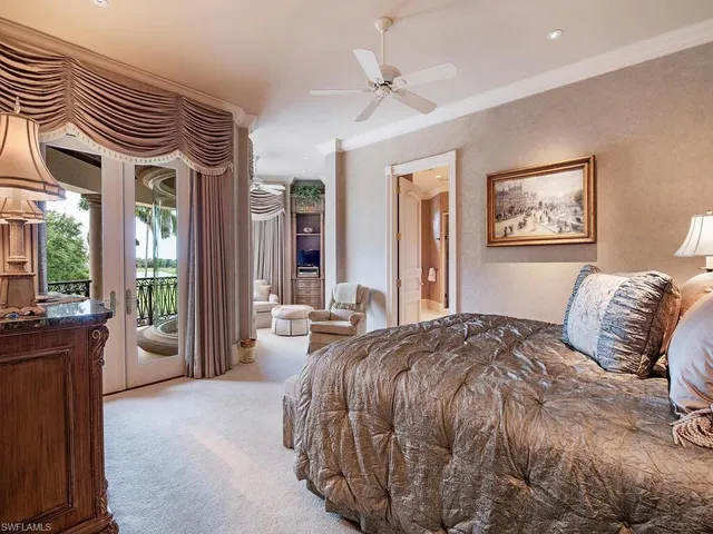 a bedroom with a large bed and a chandelier