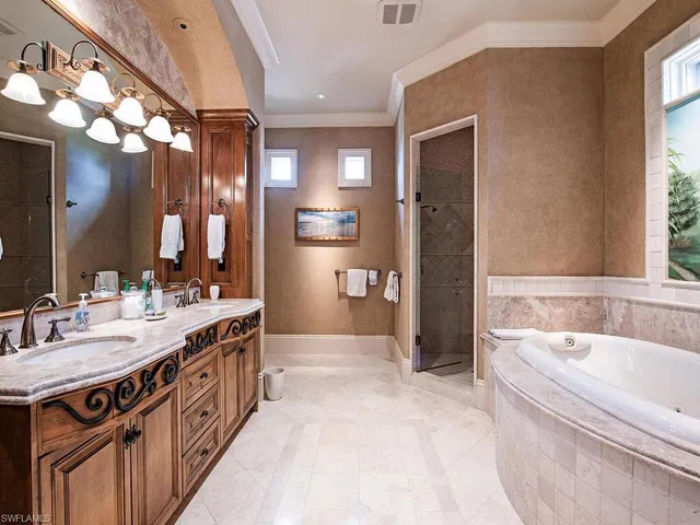 a spacious bathroom with a tub sink and mirror