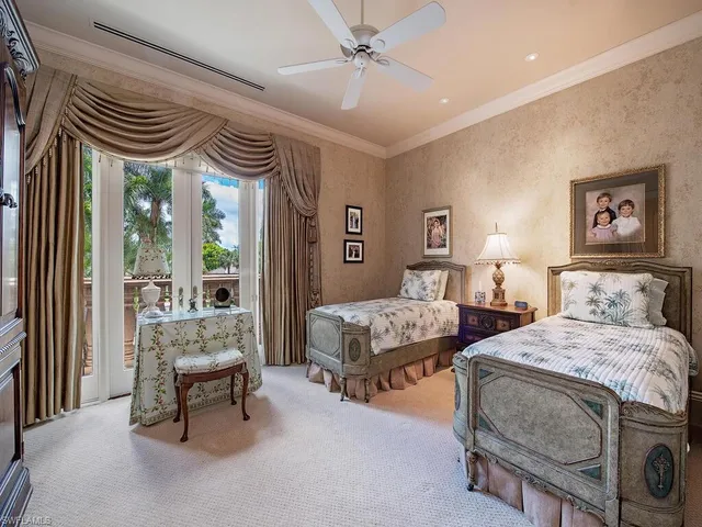 a bedroom with two beds and a chandelier