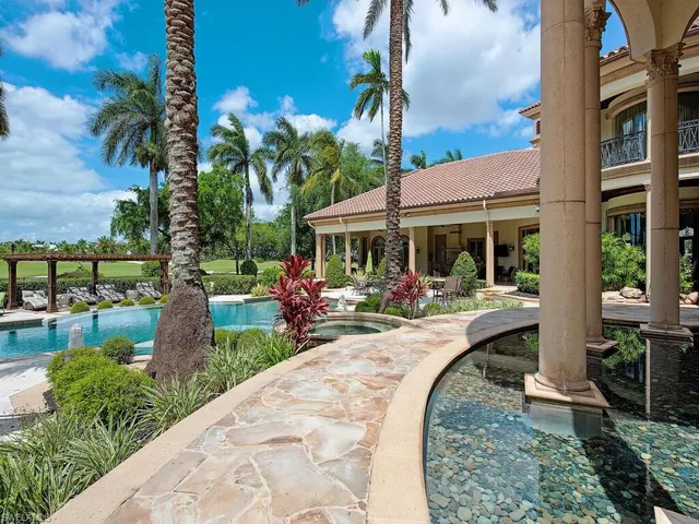 a view of a house with backyard fountain and sitting area