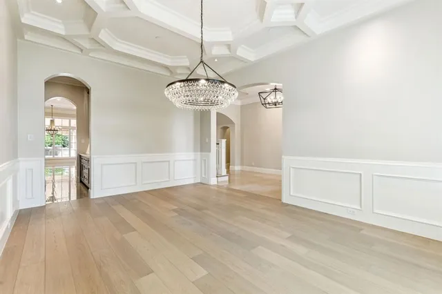 a view of a room with wooden floor and chandelier