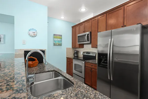 a kitchen with a refrigerator sink and stainless steel appliances