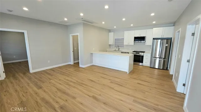 a large kitchen with stainless steel appliances granite countertop a refrigerator and a stove top oven