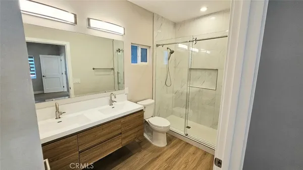 a bathroom with a double vanity sink toilet and shower