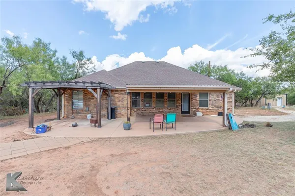 a view of a house with backyard and sitting area