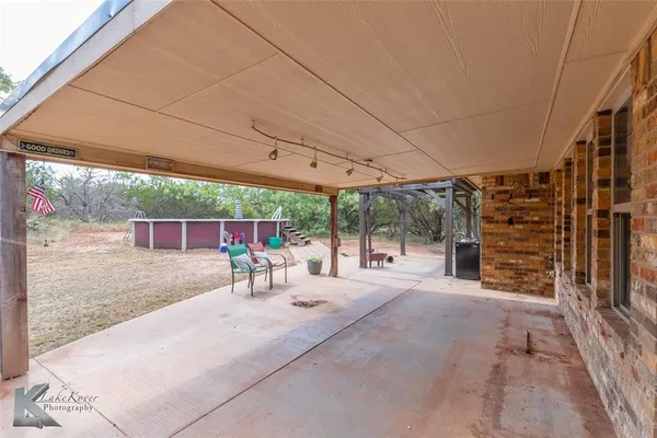 a view of a patio with a table and chairs under an umbrella