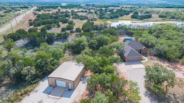 an aerial view of a house with a yard and lake view